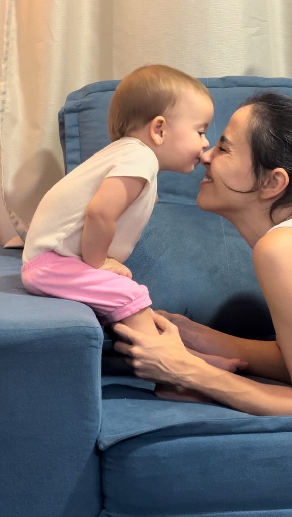 Aline Favaro nariz com nariz com a filha no sofá